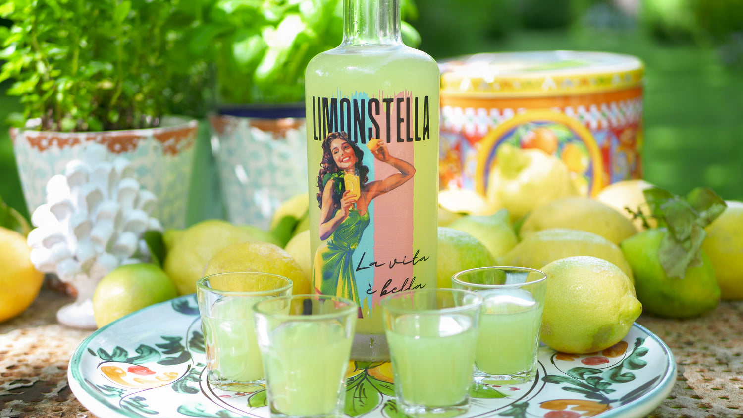 Italienischer Zitronenlikör Limoncello Flasche mit Shots in mediterranem Ambiente. Amalfi Zitronen und Kräuter.