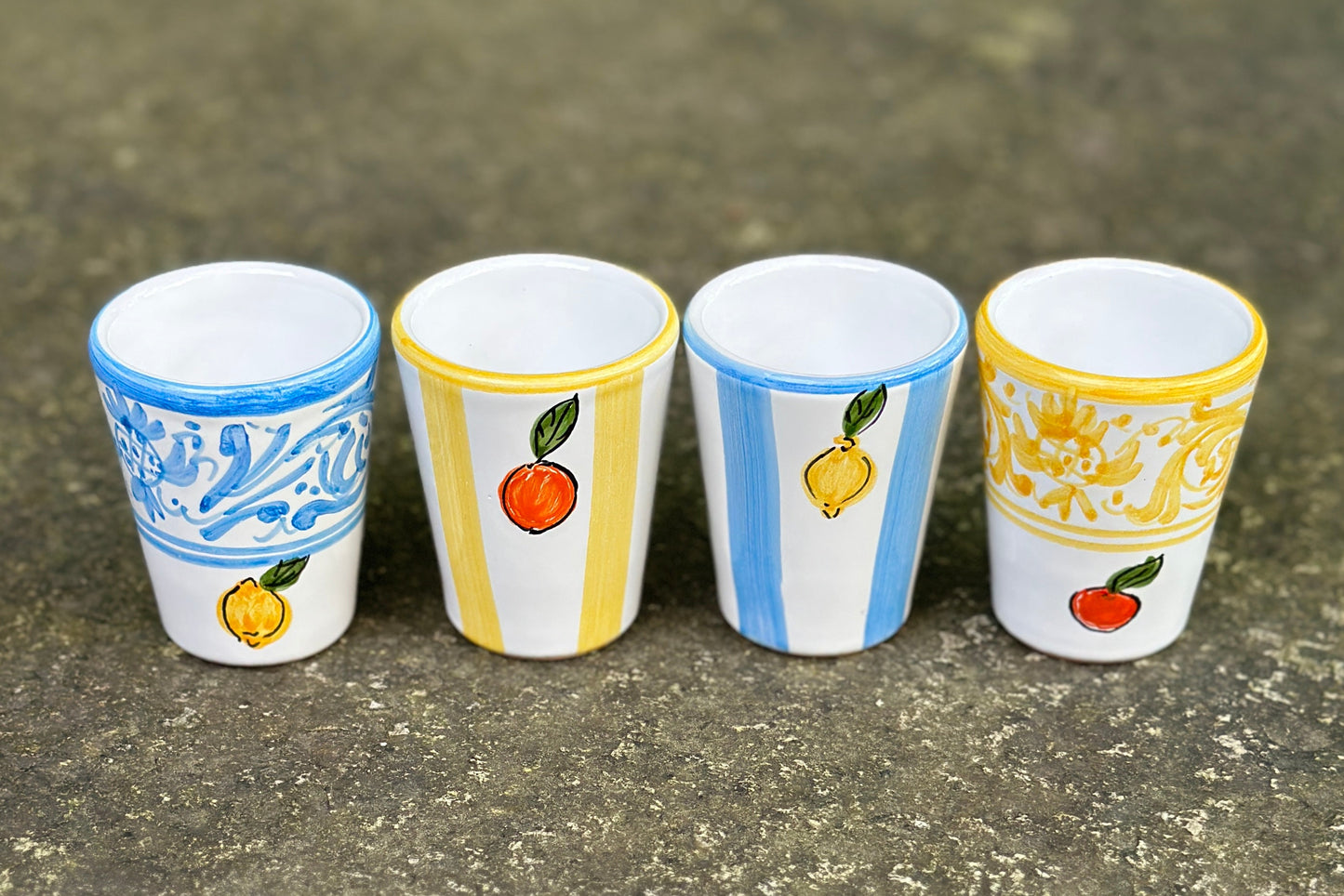 4-teiliges Set aus vier Keramikbechern für Digestif oder Espresso, handbemalt in blau-weiss mit Zitronendekor und gelb-weiss mit Orangendekor