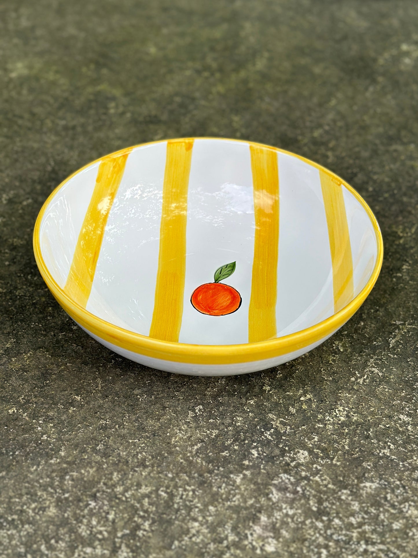 Handbemalte sizilianische Keramikschüssel mit gelb-weiss gestreiftem Muster und Orangendekor.