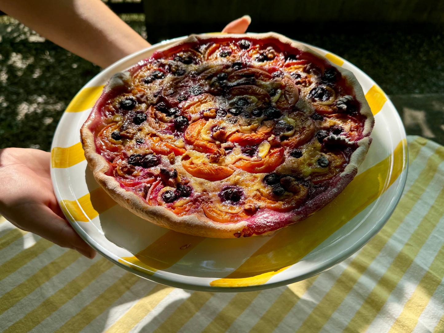 Gelb-weiss gestreifte Servierplatte mit einer sommerlichen Aprikosen-Blaubeer Tarte